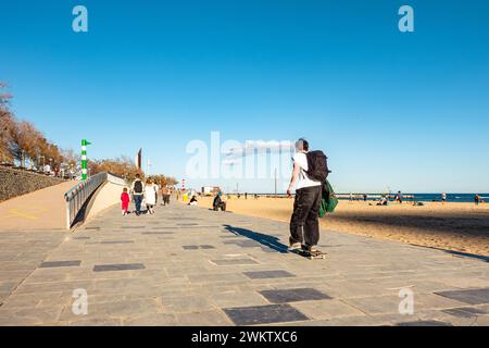 Barcelona, La Barceloneta Strand am Meer, Skateboarder Skateboarder auf dem Fußgängerweg am Meer bei Sonnenuntergang. Stockfoto