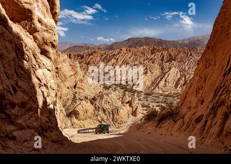 Feldweg mit Auto, der durch die Quebrada de las Flechas in Argentinien führt. Stockfoto