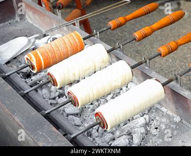 Trdelník, auch Trozkol genannt, ist eine Art Spuckkuchen aus Osteuropa, der langsam über glühender Glut gekocht und heiß mit getrockneten Früchten oder Zucker serviert wird Stockfoto