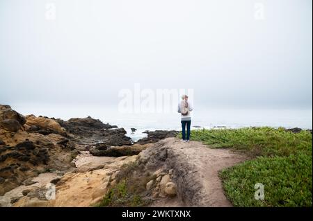 Mann mit Blick auf das Meer an nebeligen Tagen Stockfoto