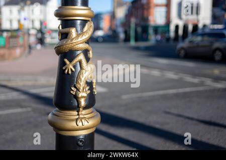 Liverpool, UK 12. Februar 2024: Nahaufnahme eines Drachen, der sich um ein schwarzes Straßenlicht in Liverpool's Chinatown gewickelt hat. Stockfoto