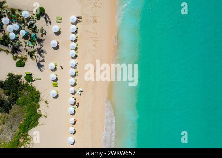 Luftaufnahme, die die Schönheit von Anguilla einfängt. Das Bild zeigt farbenfrohe Sonnenschirme auf dem unberührten weißen Sand, das türkisfarbene Wasser Stockfoto