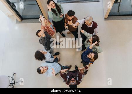 Ein Overhead Shot fängt einen warmen Moment ein, während sich eine Gruppe von Einzelpersonen in einer Show der Einheit und Freundschaft zusammenschließt. Stockfoto