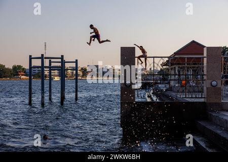 Bangkok, Thailand. Februar 2024. Jungs springen in den Chao Phraya River unter der Rama VIII Brücke in Bangkok. (Kreditbild: © Andre Malerba/ZUMA Press Wire) NUR REDAKTIONELLE VERWENDUNG! Nicht für kommerzielle ZWECKE! Stockfoto