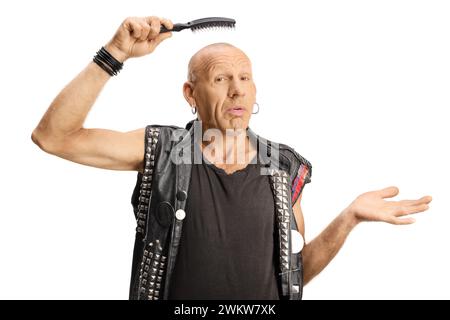 Verwirrter Mann, der eine Haarbürste über seinem Kopf hält, isoliert auf weißem Hintergrund Stockfoto