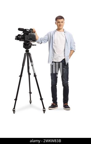 Porträt eines jungen Kamerabedieners in voller Länge mit einer Kamera auf einem Stativstativ isoliert auf weißem Hintergrund Stockfoto