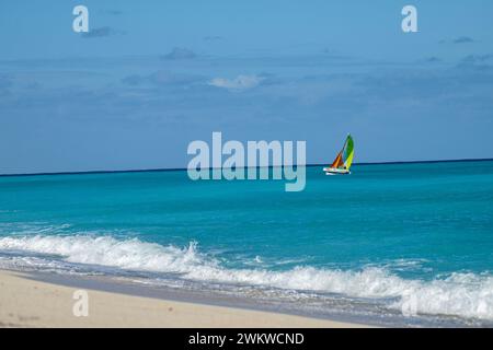 San Salvador Island Bahamas, Katamaran segelt das türkisfarbene Wasser, fast wolkenloser Himmel, bunte Segel, klares, ruhiges Wasser, aufregende Sportarten, Freude Stockfoto