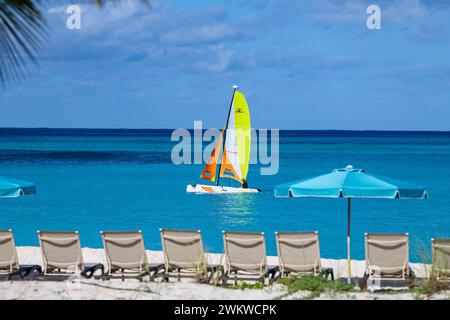 San Salvador Island Bahamas, Katamaran segelt das türkisfarbene Wasser, fast wolkenloser Himmel, bunte Segel, klares, ruhiges Wasser, aufregende Sportarten, Freude Stockfoto