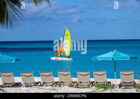 San Salvador Island Bahamas, Katamaran segelt das türkisfarbene Wasser, fast wolkenloser Himmel, bunte Segel, klares, ruhiges Wasser, aufregende Sportarten, Freude Stockfoto