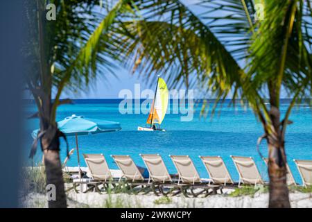 San Salvador Island Bahamas, Katamaran segelt das türkisfarbene Wasser, fast wolkenloser Himmel, bunte Segel, klares, ruhiges Wasser, aufregende Sportarten, Freude Stockfoto