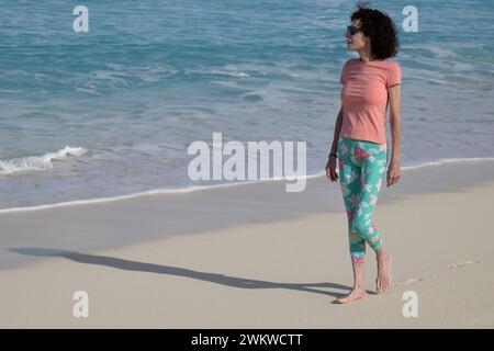 Frau, die am Strand im Club Med San Salvador Island auf Bahamas läuft Stockfoto