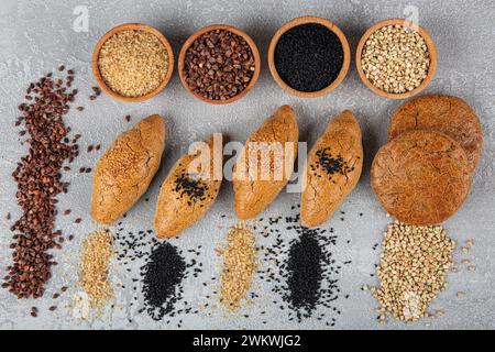 Glutenfreie Speisen. Verschiedene Snacks aus Buchweizenmehl auf hölzernem Hintergrund von oben. Hausgemachte gebackene Brötchen aus rohem Buchweizen mit Sesam. Stockfoto