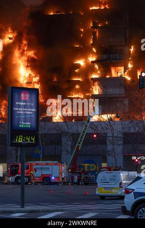 Valencia, Spanien - 22. Februar 2024: Eine Gruppe von Feuerwehrleuten entkommt einem großen Brand in einem Wohngebäude durch die Leiter des Lastwagens in der Stadt Stockfoto