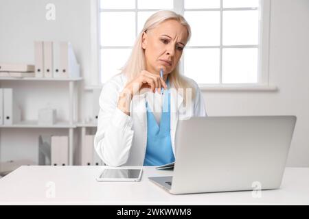 Reife Ärztin im Video-Chat mit Patientin in der Praxis Stockfoto