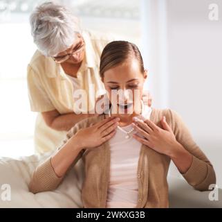 Heim, Halskette und ältere Mutter mit Frau als Geschenk, Geschenk und Überraschung im Wohnzimmer. Familie, Perlen und glückliche Tochter mit Mutter, die das Erbstück gibt Stockfoto