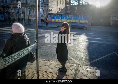 Odessa, Ukraine. Februar 2024. Eine Frau steht an einer Bushaltestelle vor einem ukrainischen Graffiti in der Hafenstadt. Am 24. Februar 2024 jährt sich der Beginn des russischen Aggressionskrieges gegen die Ukraine zum zweiten Mal. Quelle: Kay Nietfeld/dpa/Alamy Live News Stockfoto