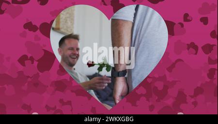 Bild von Herzen über verschiedenartiges männliches Paar, das Rose hält Stockfoto