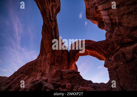 Abenddämmerung am Double Arch im Achs-Nationalpark, Moab, Utah, USA Stockfoto