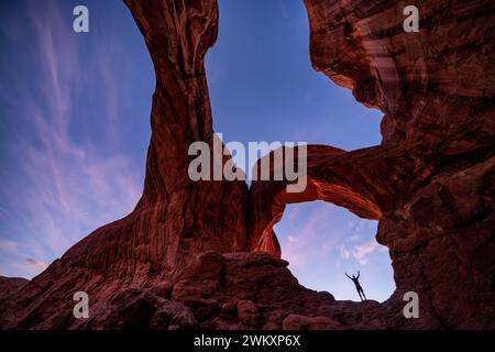 Abenddämmerung am Double Arch im Achs-Nationalpark, Moab, Utah, USA Stockfoto