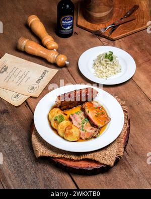 Cremige Tomatensuppe mit Pesto-Wirbel und Basilikum steht auf einem Holztisch mit knusprigem Brot Stockfoto