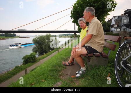 Leben an der Autobahn 40. 07.08.2009, EU, DEU, Deutschland, Nordrhein-Westfalen, Duisburg: Leben an der Autobahn 40. Radfahrer machen an der Rheinbrücke eine Pause. Die Autobahnbrücke Neuenkamp verbindet die Stadtteile Neuenkamp und Rheinhausen. EU, DEU, Deutschland, Nordrhein-Westfalen, Duisburg: Leben auf der Autobahn 40, Radfahrer machen eine Pause an der Rheinbrücke. Die Autobahnbrücke Neuenkamp verbindet die Stadtteile Neuenkamp und Rheinhausen. Stockfoto