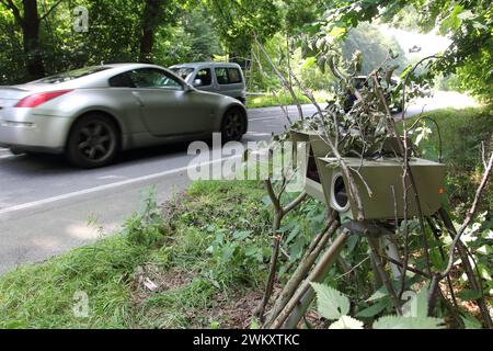 Strassenverkehr im Ruhrgebiet. 17.07.2014, EU, DEU, Deutschland, Nordrhein-Westfalen, Hattingen: mit Aesten und Laub getarnte Radarfalle an der Wodantalstrasse. EU, DEU, Deutschland, Nordrhein-Westfalen, Hattingen: Mit Ästen und Laub getarnte Geschwindigkeitsfalle an der Wodantalstraße. Stockfoto