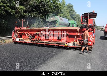 Leben an der Autobahn 40. 17.07.2015, EU, DEU, Deutschland, Nordrhein-Westfalen, Essen: Sperrung der Autobahn-40 für Erneuerungsarbeiten. Auftragen von sog. Fluesterasphalt zwischen Wattenscheid und Frillendorf. EU, DEU, Deutschland, Nordrhein-Westfalen, Essen: Autobahn 40 wegen Renovierungsarbeiten gesperrt. Die Anwendung von sogenanntem Fluester-Asphalt zwischen Wattenscheid und Frillendorf. Stockfoto