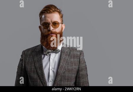 Tuxedo bärtiger Mann in eleganter formeller Herrenbekleidung mit Anzugsjacke und Schleife isoliert auf Grau, Kopierraum Stockfoto