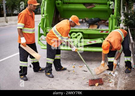 Müllwagen, Besen und Leute mit Abholservice auf der Straße in der Stadt zur Reinigung der öffentlichen Umwelt. Müll, Recycling und Männer, die mit Abfall arbeiten Stockfoto