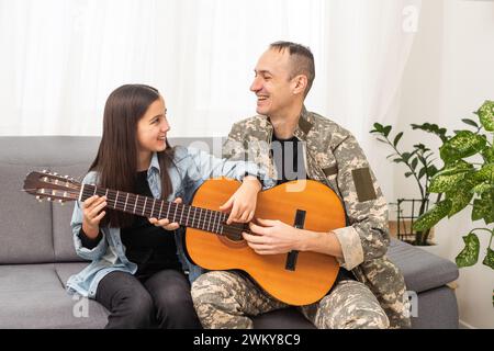 Ein Veteran und seine Tochter spielen Gitarre Stockfoto