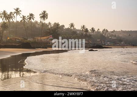 Panoramablick auf den Strand von Vagator oder Ozran im Norden von Goa, Indien. Goa Beach am frühen Morgen vor Sonnenaufgang Blick auf Palmen und Restaurants auf der bea Stockfoto