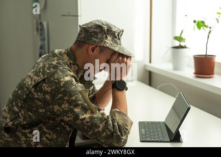 Ein verzweifelter Soldat, der sein Gesicht bedeckt, möglicherweise unter einem Muschelschock oder einer posttraumatischen Belastungsstörung leidet Stockfoto