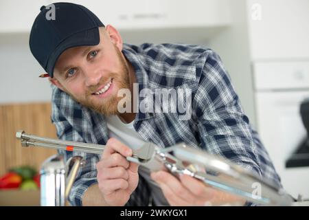 Klempner, der Metallschläuche für Spülbecken montiert Stockfoto