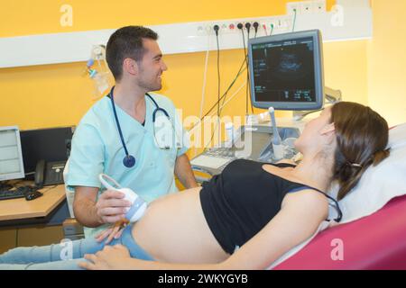 Schwangere Frau, die Ultraschallbehandlung im Krankenhaus Stockfoto