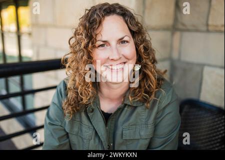 Freudige Frau mit lockigen Haaren Stockfoto