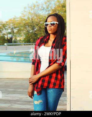 Porträt einer schönen jungen afrikanerin, die in der Stadt mit einer Sonnenbrille posiert Stockfoto