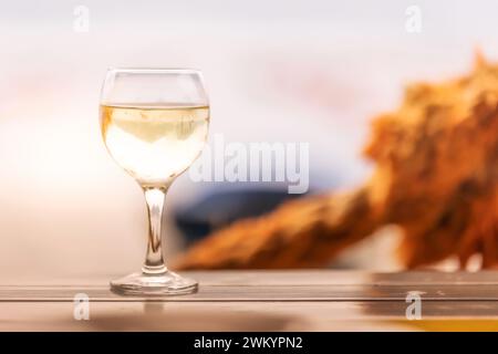 Weißer Wein auf dem Holztisch, Küstencafé, Hintergrund Austernfarm Stockfoto