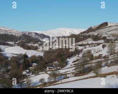 Schneebedeckte Häuser und Landschaft im Longsleddale Tal von der A6 Kendal bis Penrith Road. Stockfoto