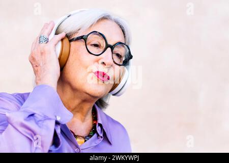 Lächelnde Seniorin, die gerne Musik hört Stockfoto