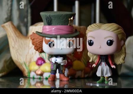 Funko Pop Actionfiguren von Mad Hatter und Alice im Wunderland. Palast, Säulen, Teekanne, Spiegelboden, grüner Vorhang, fabelhaft, fantasievoll, stimmungsvoll. Stockfoto