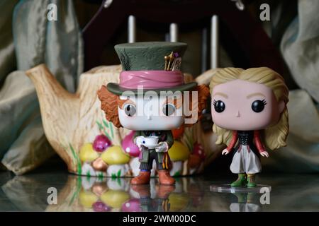 Funko Pop Actionfiguren von Mad Hatter und Alice im Wunderland. Palast, Säulen, Teekanne, Spiegelboden, grüner Vorhang, fabelhaft, fantasievoll, stimmungsvoll. Stockfoto