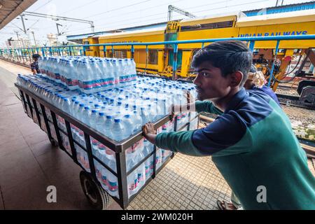 Trolley-Ladung mit Trinkwasser in Flaschen wird an einem indischen Bahnhof bewegt Stockfoto