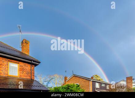 Wetter in Großbritannien: Ein doppelter Regenbogen bildet sich am Himmel über einem Garten während des Regens in Surrey, Südosten Englands im Winter Stockfoto