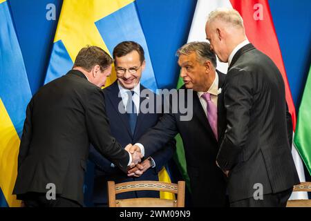 Budapest, Ungarn. Februar 2024. Göran Martensson (l-r), Generaldirektor der schwedischen Verteidigungsmaterialverwaltung, schwedischer Premierminister Ulf Kristersson, ungarischer Premierminister Viktor Orban und ungarischer Verteidigungsminister Kristof Szalay-Bobrovniczky auf einer gemeinsamen Pressekonferenz in Budapest. Kurz vor der erwarteten Zustimmung Ungarns zum NATO-Beitritt Schwedens haben sich die beiden Länder auf ein umfassendes Rüstungsabkommen geeinigt. Quelle: Marton Monus/dpa/Alamy Live News Stockfoto