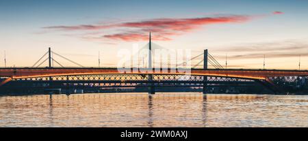 Herrlicher Sonnenuntergang über dem Fluss Save in Belgrad, Serbien, leuchtende Brücke und umliegende Stadtlandschaft mit einem goldenen Glanz. Stockfoto