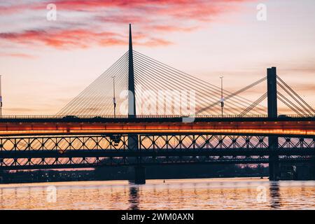 Herrlicher Sonnenuntergang über dem Fluss Save in Belgrad, Serbien, leuchtende Brücke und umliegende Stadtlandschaft mit einem goldenen Glanz. Stockfoto