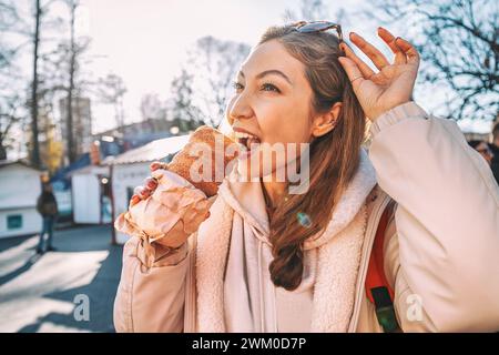 Unwiderstehliches Aroma von frisch gebackenem Trdelnik-Kuchen, einem traditionellen tschechischen Gebäck, das für seine verführerische Süße und seine einzigartige Form des Kamins bekannt ist. Stockfoto