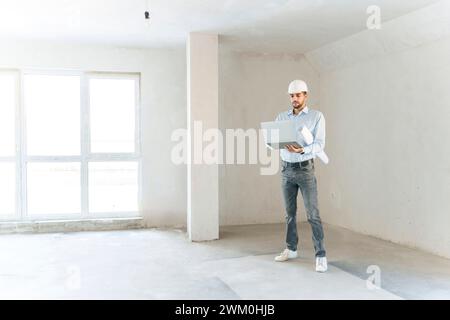 Glücklicher Architekt mit Laptop vor Ort Stockfoto