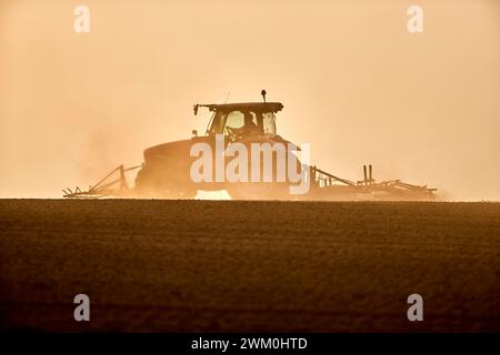 Landwirt im Traktor mit Pflug bereitet das Feld vor Stockfoto