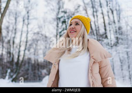 Lächelnde Frau in warmen Kleidern im Winterwald Stockfoto